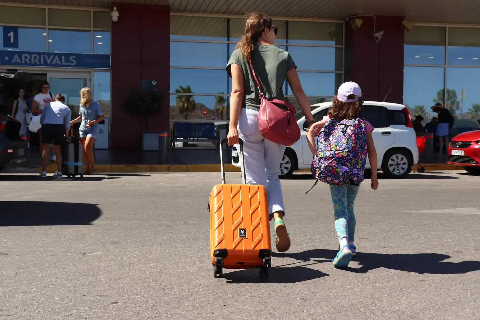 Woman with child walking toward Chania Airport (CHQ) before departure, August 2025 — photo by Zurab Peikrishvili | CreteTales.com