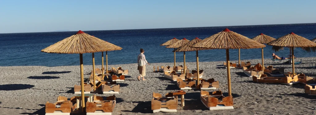 Sunbeds and straw umbrellas on Sougia Beach with the Libyan Sea in southern Crete