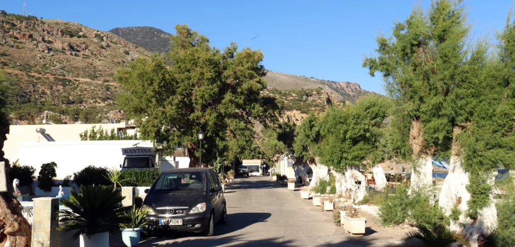 Main street with hotels, tavernas and parking near Sougia Beach, Crete