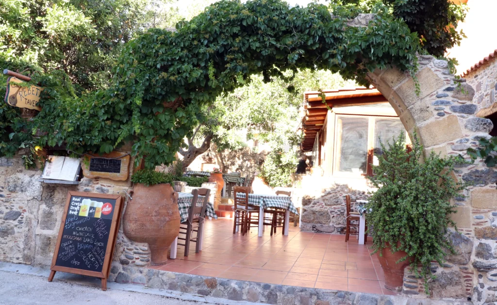 Traditional stone taverna with vine-covered entrance in Sougia village, Crete