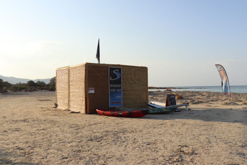 Surf Island rental area with boards and price sign at Elafonissi Beach
