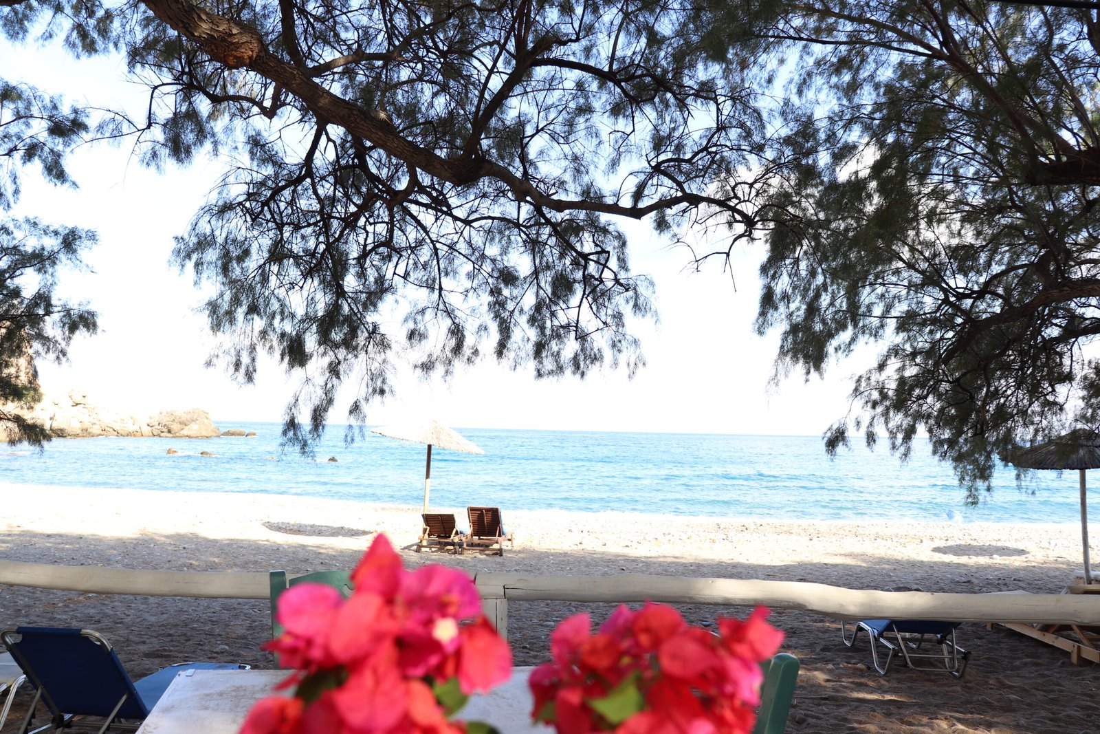 View to Sfinari beach and sea from the taverna table with flowers