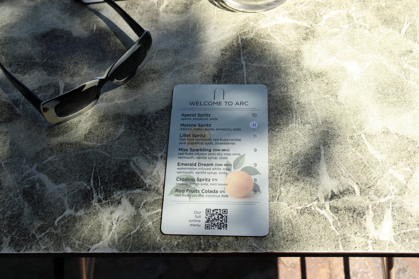 ARC Café Menu — Agios Nikolaos ARC Café menu on the outdoor table in Agios Nikolaos showing signature spritz cocktails — summer 2025