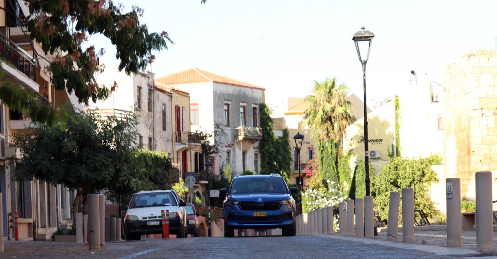 Driving in Chania Old Town narrow street taxi