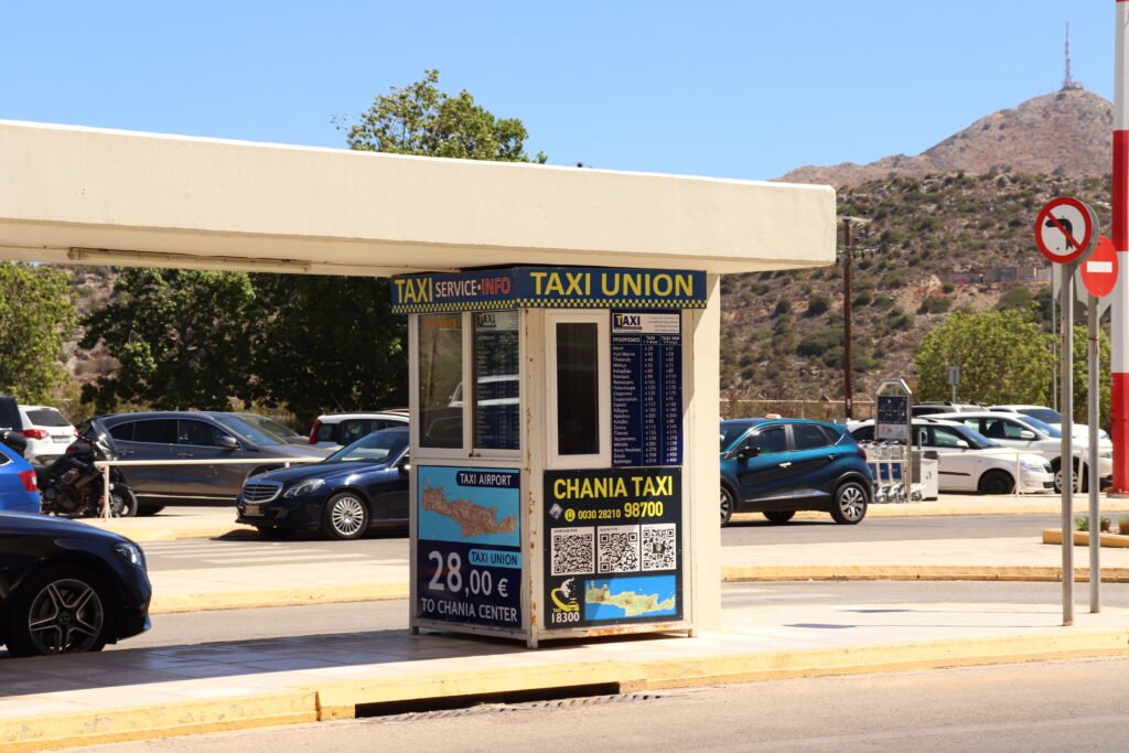 Taxi Union kiosk at Chania Airport showing official taxi prices to Chania city center