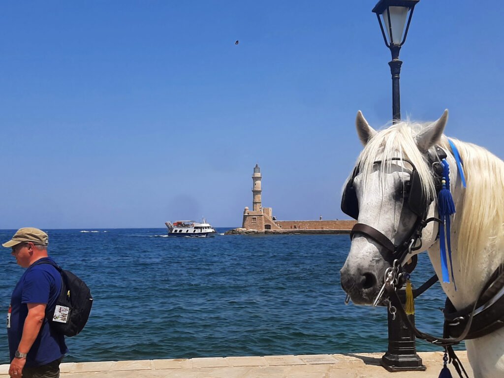 Horse carriage at the Old Venetian Harbour with a view of the Chania lighthouse