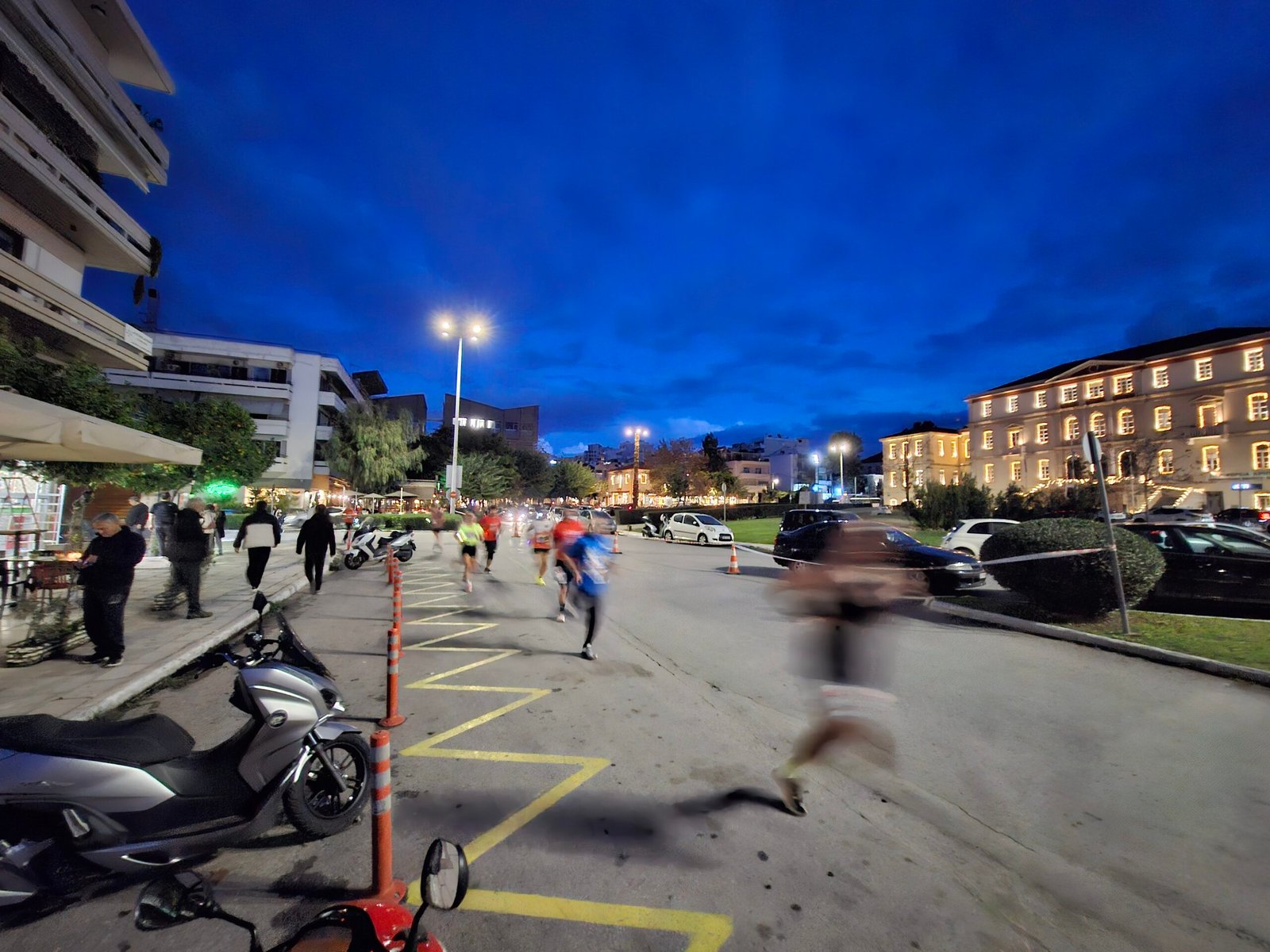 Runners passing the illuminated administrative building in Chania