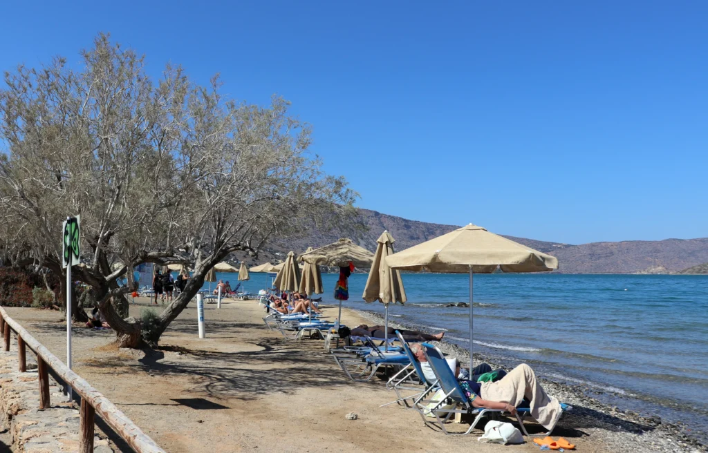 Sunbeds and umbrellas on a quiet family-friendly beach in Elounda, Crete