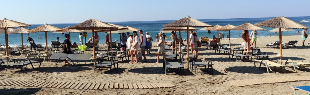Visitors enjoying a beach in Crete at the beginning of the swimming season