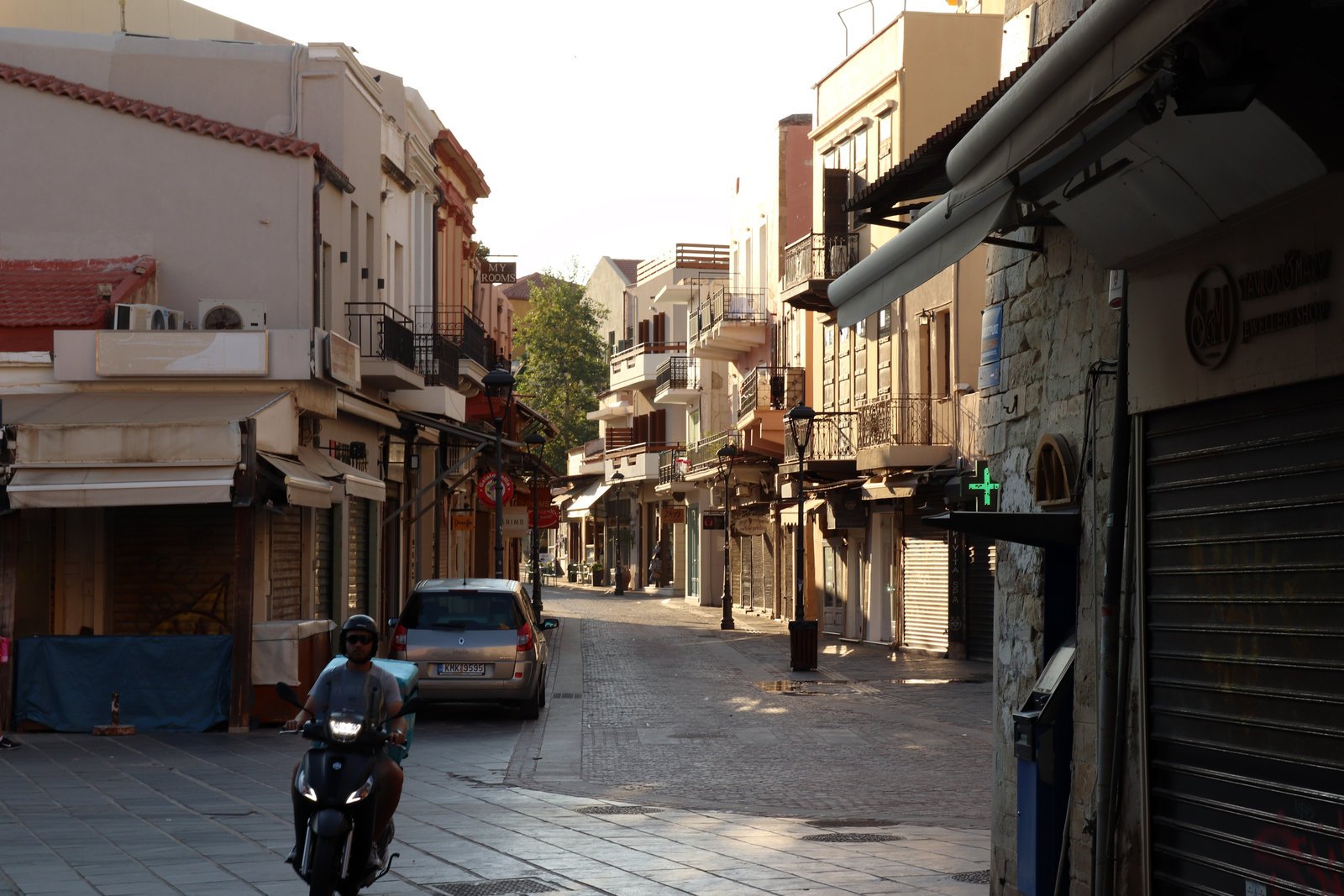 driving in Chania Old Town narrow street with car and scooter Crete