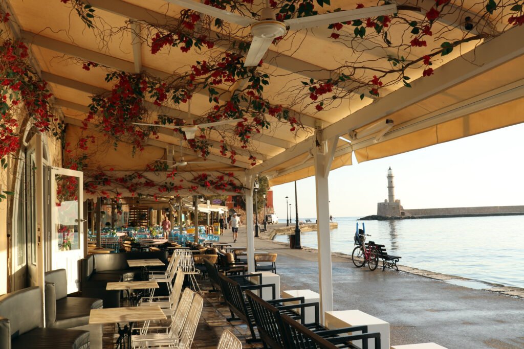 Traditional tavernas on the Chania Old Town harbor waterfront at sunrise in Crete, Greece.