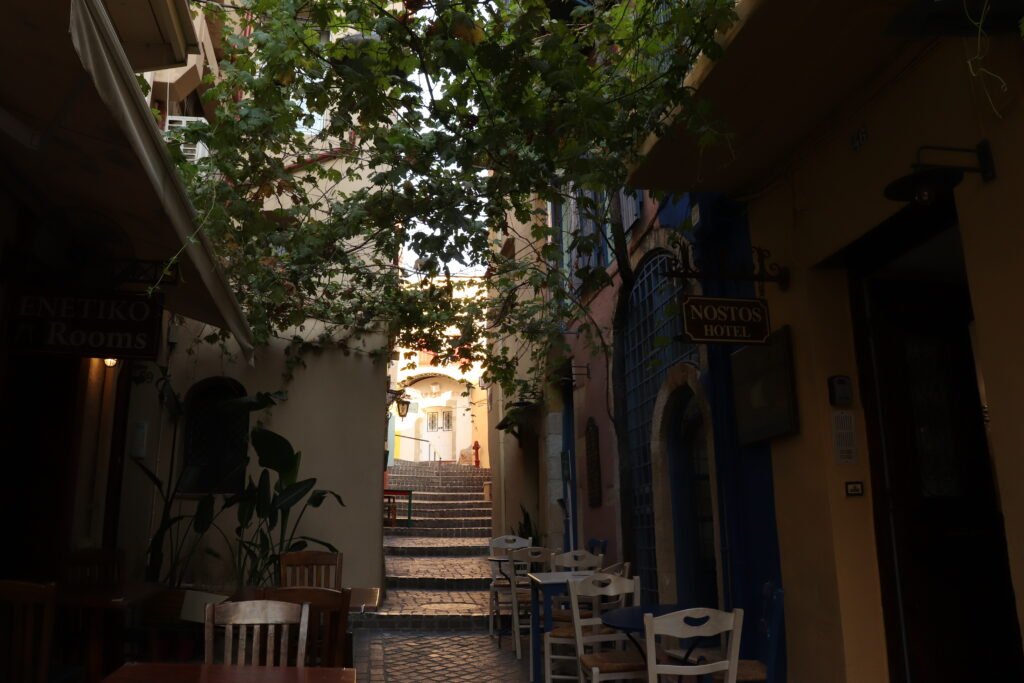 Hidden courtyard passage with small cafe tables in Chania Old Town, Crete