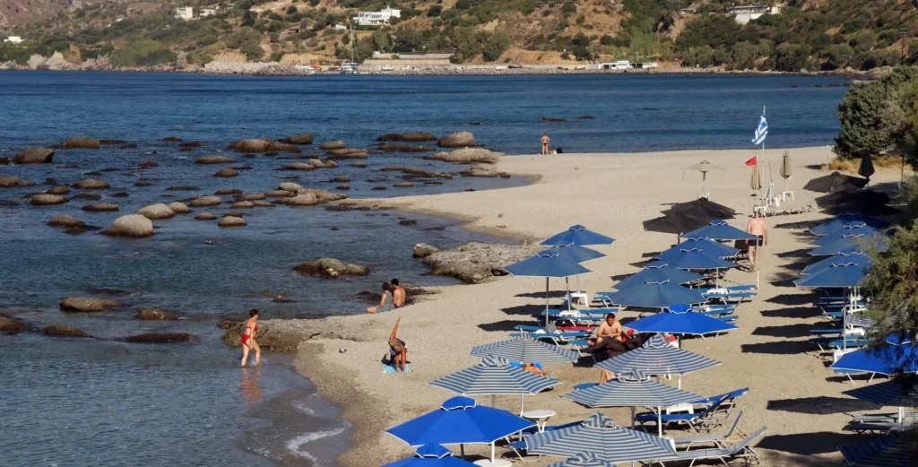 Beach with sunbeds and visitors during the summer season in Crete