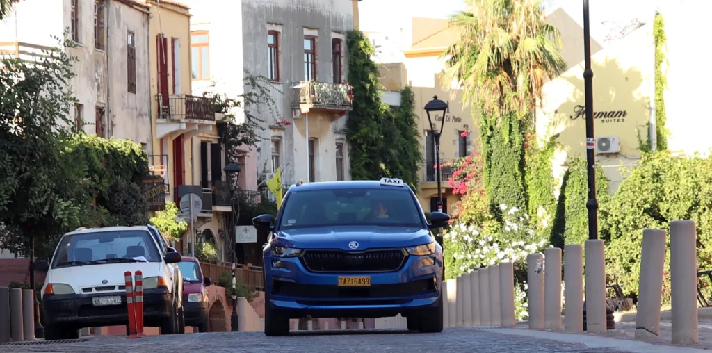 Taxi driving through a street in Chania Old Town during an early summer morning in Crete