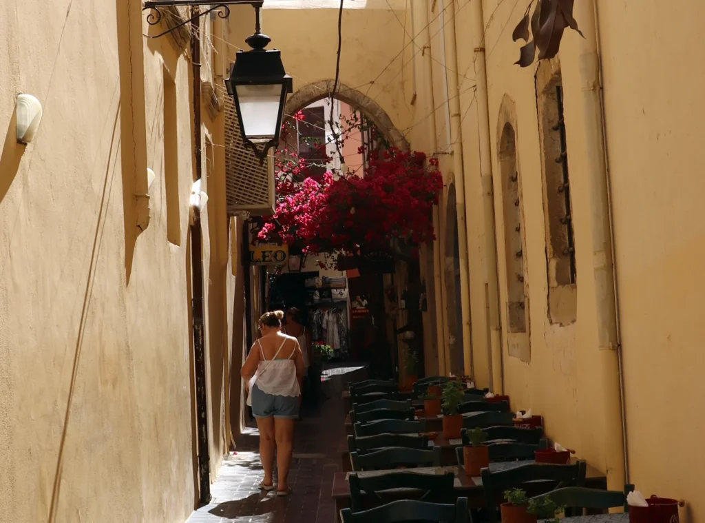 Narrow street in Rethymno Old Town with a stone arch and bougainvillea